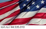 A close-up shot of the American flag fluttering in the wind. Крупным планом флаг США, развевающийся на ветру. Стоковое видео, видеограф Валерий Тесаков / Фотобанк Лори