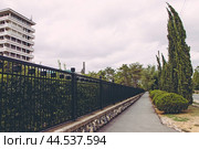 Крым, Евпатория, курорт, архитектура, санаторий Таврия, девятиэтажка, кипарисы, тротуар. Редакционное фото, фотограф Андрей Макаренко / Фотобанк Лори