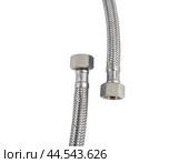 Сантехнический шланг в металлической оплетке для воды на белом фоне. Plumbing hose in a metal braid for water. Стоковое фото, фотограф Татьяна Д / Фотобанк Лори