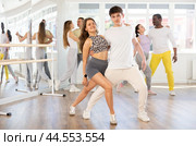 Young woman dances incendiary tango with man partner during choreography lesson. Стоковое фото, фотограф Яков Филимонов / Фотобанк Лори