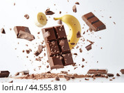 Banana and chocolate explosion in mid-air. Стоковое AI-изображение, AI-художник Иван Рябоконь / Фотобанк Лори