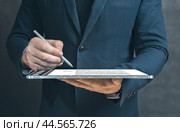 Close up businessman hand hold tablet pc and electronic Signature. Write business agreement of contract. Man signing contract on digital tablet. Business and technology concept. Стоковое фото, фотограф Павел Муравьев / Фотобанк Лори