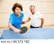 Happy mature man and woman playing table tennis. Стоковое фото, фотограф Татьяна Яцевич / Фотобанк Лори