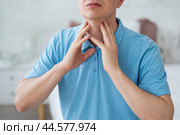 Thyroid gland inflammation, sore throat and cough, man with neck pain at home. Стоковое фото, фотограф Станислав Тарко / Фотобанк Лори