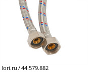 Сантехнический шланг в металлической оплетке для воды на белом фоне. Plumbing hose in a metal braid for water. Стоковое фото, фотограф Татьяна Д / Фотобанк Лори