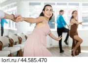 Couple in evening dresses enjoys pair dance boogie-woogie, interacting with each other on floor. Стоковое фото, фотограф Яков Филимонов / Фотобанк Лори