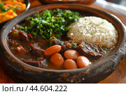 Traditional brazilian feijoada with rice, beans, and greens served in a clay pot. Стоковое AI-изображение, AI-художник Иван Рябоконь / Фотобанк Лори
