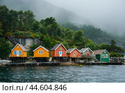 Colorful waterside cabins in misty nordic landscape. Стоковое AI-изображение, AI-художник Иван Рябоконь / Фотобанк Лори