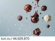 Levitating assorted chocolates on blue background. Стоковое AI-изображение, AI-художник Иван Рябоконь / Фотобанк Лори