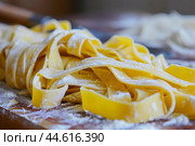 Fresh homemade pasta on wooden surface. Стоковое AI-изображение, AI-художник Иван Рябоконь / Фотобанк Лори