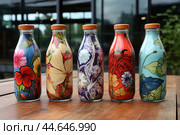 Colorful floral patterned reusable bottles. Стоковое AI-изображение, AI-художник Иван Рябоконь / Фотобанк Лори