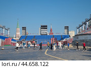 Туристы фотографируются на фоне трибун на Красной площади в дни проведения военно-музыкального фестиваля "Спасская башня". Москва, Россия (2024 год). Редакционное фото, фотограф Елена Коромыслова / Фотобанк Лори