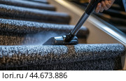 A person vacuuming a carpeted staircase in a modern home during the afternoon light to maintain cleanliness and hygiene. Стоковое AI-изображение, AI-художник Сергей Толмачёв / Фотобанк Лори
