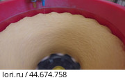 Mixing Brown Powder in a Red Bucket With a Yellow Center. Стоковое видео, видеограф Гурьянов Андрей / Фотобанк Лори