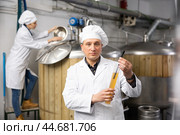 Brewmaster measuring beer density with digital hydrometer in brewery. Стоковое фото, фотограф Яков Филимонов / Фотобанк Лори