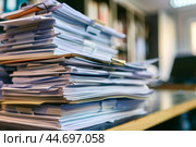Stack of documents piling up on a busy office desk. Стоковое AI-изображение, AI-художник Иван Рябоконь / Фотобанк Лори