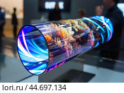 Cylindrical oled display showing colorful abstract visuals at consumer electronics show. Стоковое AI-изображение, AI-художник Иван Рябоконь / Фотобанк Лори