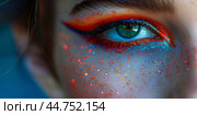 Close-up of a vibrant eye with colorful makeup, including red and blue eyeshadow, with glitter  sprinkled on the skin around the eye. Стоковое AI-изображение, AI-художник Anastacia Gaikova / Фотобанк Лори