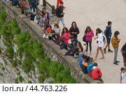Zumaia / Spain - June 11, 2019: Tourists on viewpoint of charming Zumaia Itzurun beach in Basque Autonomous Community / country in summer day. It's teenager school group. Редакционное фото, фотограф YuryKara / Фотобанк Лори