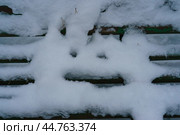 Снег в форме смайлика на спинке лавочки в городском парке. Стоковое фото, фотограф YuryKara / Фотобанк Лори