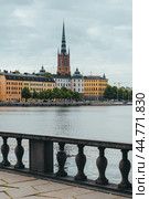 Old Town Waterfront. Gamla Stan, Stockholm, Sweden. Riddarholmen church with spire and colorful historical buildings. (2019 год). Стоковое фото, фотограф KOSIM / Фотобанк Лори