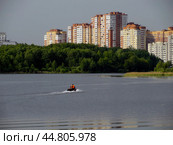 Спасатели в лодке на реке Пехорка и многоэтажные жилые дома в городе Балашиха, Московская область. Солнечный летний день. (2019 год). Стоковое фото, фотограф Александр Кузнецов / Фотобанк Лори