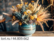 A beautiful bouquet of dried flowers in a ceramic vase on an antique wooden chest of drawers. A bouquet of flowers in a vase in a home interior. Light, beige, blue floral background. Стоковое AI-изображение, AI-художник Photojuli / Фотобанк Лори