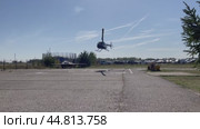 Вертолет Robinson R44 заходит на посадку и приземляется на размеченную площадку. Аэродром "Мячково", аэроклуб "Кондор-М" Редакционное видео, видеограф Щеголева Ольга / Фотобанк Лори