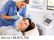 Elderly female client receiving hardware ultrasonic to revitalize and tighten facial skin at cosmetology clinic. Стоковое фото, фотограф Яков Филимонов / Фотобанк Лори