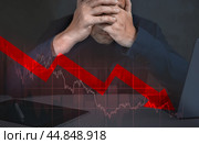Depressed business man looking down at falling red arrow. desperate about losing money of crisis, recession, inflation. Стоковое фото, фотограф Павел Муравьев / Фотобанк Лори