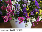 Bouquet of multicolored flowers in a vase (Limonium sinuatum, Statice sinuata) on a green background. Стоковое фото, фотограф Ирина Вершинская / Фотобанк Лори