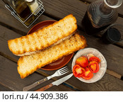 Crispy toasted white bread slices, fresh tomatoes and garlic served on plates. Ingredients for traditional Catalan tapas Pan con tomate. Стоковое фото, фотограф Яков Филимонов / Фотобанк Лори