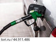 The gas station. Filling the car with gasoline. A Russian fuel dispenser in the fuel tank of a car at a gas station. Rising fuel prices around the world. Стоковое фото, фотограф Photojuli / Фотобанк Лори