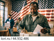 President elections. A black man votes for the new president of the United States of America and puts a form in the ballot box against the background of the American flag. Стоковое AI-изображение, AI-художник Photojuli / Фотобанк Лори