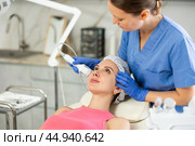Caucasian brunette girl lying in spa while having facial treatment procedures with modern technologies shrink pores and repair damaged skin. Hardware cosmetology and dermatology. Стоковое фото, фотограф Яков Филимонов / Фотобанк Лори