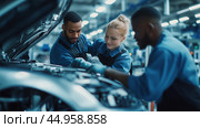 Team of mechanics working together on a car engine in an automotive workshop during daylight hours. Стоковое AI-изображение, AI-художник Сергей Толмачёв / Фотобанк Лори