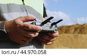 a surveyor on a construction site controls a quadcopter. Стоковое видео, видеограф Igor Skripachev / Фотобанк Лори