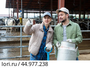 Farmer couple standing with milk churn at livestock farm and talking. Стоковое фото, фотограф Яков Филимонов / Фотобанк Лори