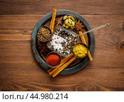 Oriental spice set - coriander, red pepper, turmeric, cinnamon, star anise, various seasonings in metall plate, on brown dark wooden table, top view, macro. Стоковое фото, фотограф Natalia Gdovskaia / Фотобанк Лори
