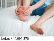 Foot pain, corns and calluses, dry skin on legs, man suffering from feet ache, podiatry concept. Стоковое фото, фотограф Станислав Тарко / Фотобанк Лори