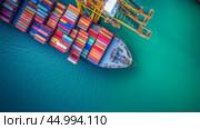 Cargo ship loading containers at a busy port under clear blue skies during daytime operations. Стоковое AI-изображение, AI-художник Сергей Толмачёв / Фотобанк Лори