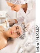 Young woman cosmetologist doing microcurrent procedure to young woman. Стоковое фото, фотограф Яков Филимонов / Фотобанк Лори
