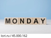 Word Monday on wooden cubes. Weekday concept. Monday inscription on wooden cubes on blue background. copy space. Стоковое фото, фотограф Павел Муравьев / Фотобанк Лори