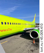 IRKUTSK, RUSSIA - September 13, 2024: View of the board of a modern green S7 Airlines aircraft from a mobile passenger ramp on a sunny summer day. Редакционное фото, фотограф Виктория Катьянова / Фотобанк Лори