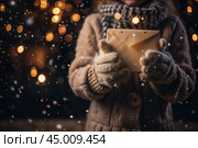 A little girl in winter clothes holding an envelope outside in snowy weather against the background of lights. A letter for Santa Claus. The winter atmosphere of a festive invitation. Стоковое AI-изображение, AI-художник Photojuli / Фотобанк Лори