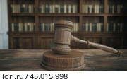 Gavel resting on wooden block in a law library filled with legal books and resources. Стоковое AI-изображение, AI-художник Юлия Гапеенко / Фотобанк Лори