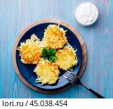 Crispy hashed browned potatoes on blue background, top view. Стоковое фото, фотограф Natalia Gdovskaia / Фотобанк Лори