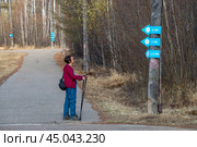 Женщина на прогулке с палками для скандинавской ходьбы (2022 год). Редакционное фото, фотограф Геннадий Соловьев / Фотобанк Лори