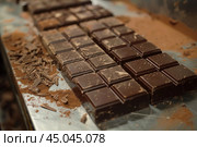 Chocolate bars cooling on metal table after tempering process. Стоковое AI-изображение, AI-художник Иван Рябоконь / Фотобанк Лори