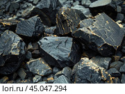 Closeup of black obsidian rocks showing rough texture and natural patterns. Стоковое AI-изображение, AI-художник Иван Рябоконь / Фотобанк Лори